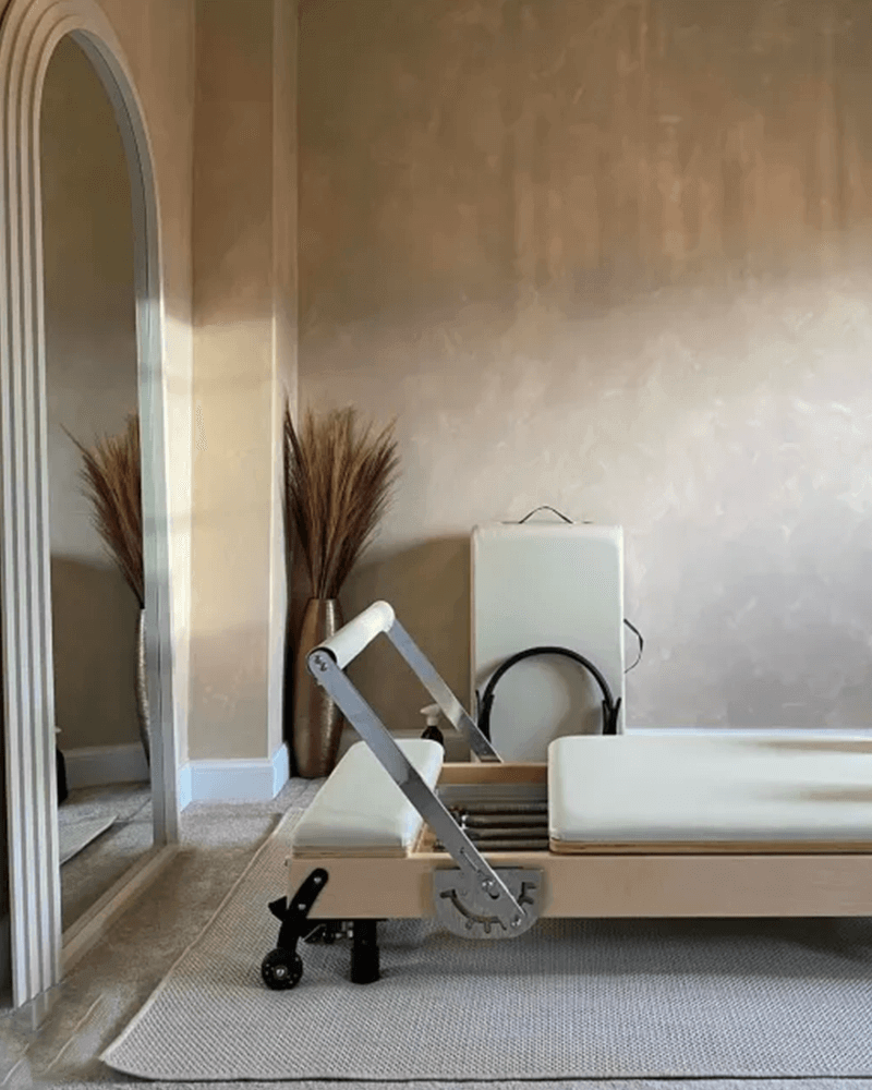Modern interior with a massage table and mirrors in a neutral-toned room.