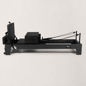 FOLD STUDIO Reformer machine in black oak with vegan-friendly upholstery, designed for home and commercial use.