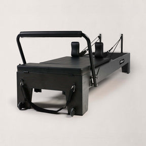 FOLD STUDIO Reformer machine in premium hardwood with black vegan upholstery, ideal for home and commercial use.
