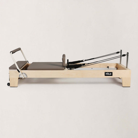FOLD STUDIO Reformer with a premium hardwood frame and mocha upholstery, ideal for home and commercial use.