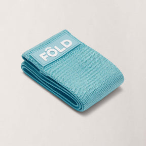 Pilates Resistance Band - Baby Blue Medium rolled up, showcasing its premium design and elegant color.