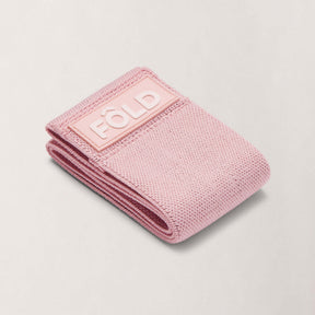 Pilates Resistance Band - Rose Pink Light folded, showcasing its premium design and soft pink color.