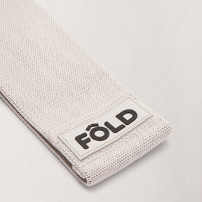 Pilates Resistance Band - Timber Wolf Medium showing close-up of FÔLD logo and texture detail.