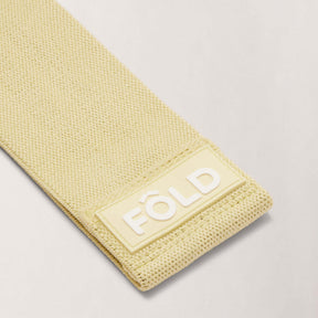 Pilates Resistance Band - Yellow Light close-up showing texture and FÔLD logo for optimal grip during exercises.