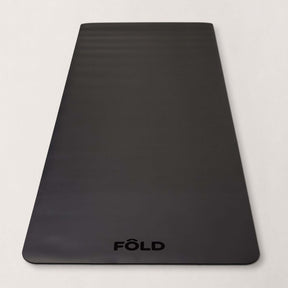 FOLD Yoga Mat - Black, providing grip and cushioning for yoga, Pilates, and home workouts.