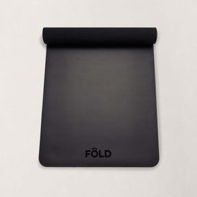 FOLD Yoga Mat - Black with a smooth surface and logo, perfect for yoga and Pilates sessions.