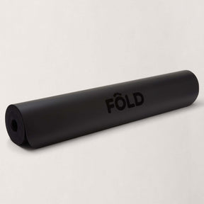 FOLD Yoga Mat - Black rolled up, showcasing its sleek design for yoga and Pilates sessions.