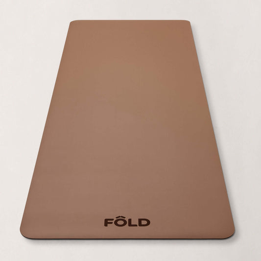 FOLD Yoga Mat - Caramel on a neutral background, designed for yoga, Pilates, and home workouts.