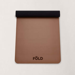 FOLD Yoga Mat - Caramel with a black rolled edge, ideal for yoga and Pilates sessions, offering grip and stability.