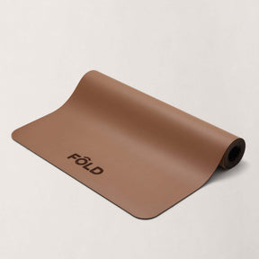 FOLD Yoga Mat - Caramel displaying a rolled-up design, perfect for yoga and Pilates workouts.