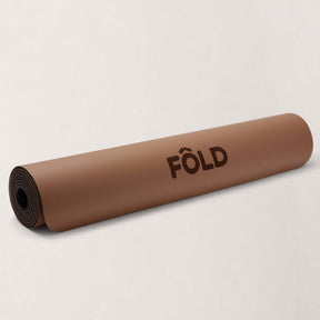 FOLD Yoga Mat - Caramel rolled out for yoga and Pilates sessions with grip and stability features.