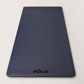 FOLD Yoga Mat - Navy on a light background, showcasing its sleek design and textured surface for optimal grip.