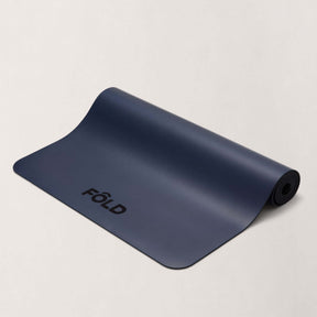 FOLD Yoga Mat - Navy lays flat showcasing its grip and cushioning for yoga and Pilates sessions.