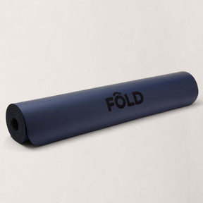 FOLD Yoga Mat - Navy rolled up, perfect for yoga, Pilates, and home workouts with enhanced grip and stability.