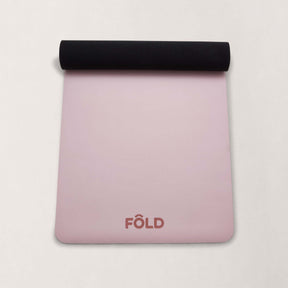 FOLD Yoga Mat - Pink with black roll, designed for grip, cushioning, and stability during yoga and Pilates workouts.