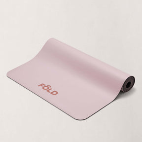FOLD Yoga Mat - Pink displayed on a pale background, showcasing its grip and cushioning design for yoga and Pilates.