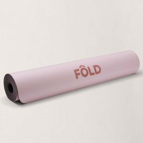 FOLD Yoga Mat - Pink rolled up, showcasing its soft surface for yoga and Pilates workouts.