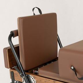 FÔLD Jumpboard on a FÔLD Reformer with Chocolate upholstery