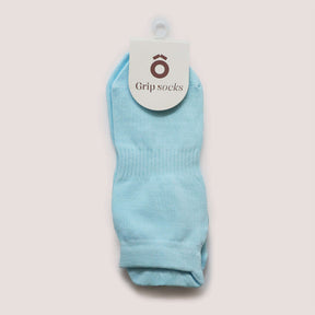 Pilates Low Rise Grip Socks - Baby Blue displayed with a tag showing 'Grip socks' on a light pink background.