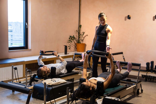 Choosing the Right Pilates Studio Platform: Instructors guiding clients in a reformer Pilates class.