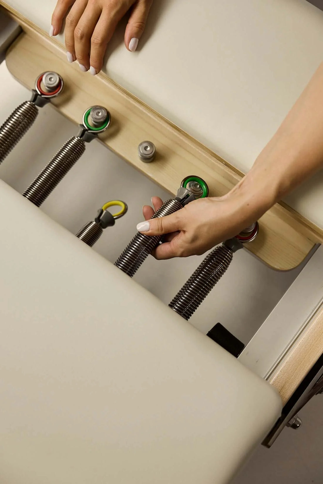 Understanding reformer spring resistance and finding the right tension for you, adjusting springs on a Pilates reformer.