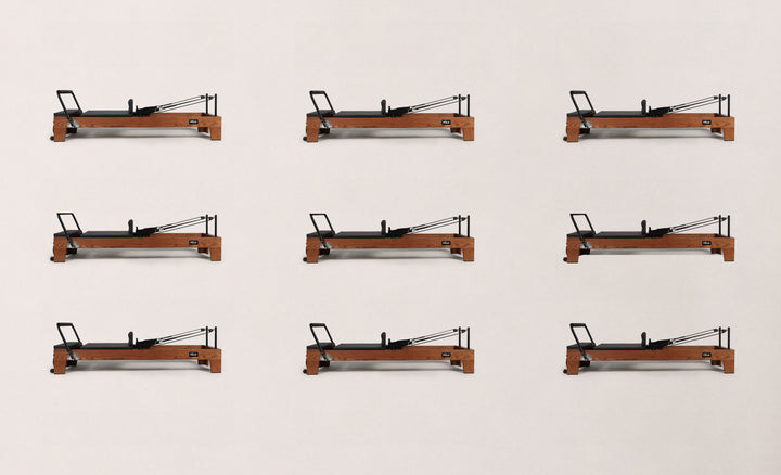 Nine reformers for pilates arranged in a grid, showcasing their sleek design and functionality.