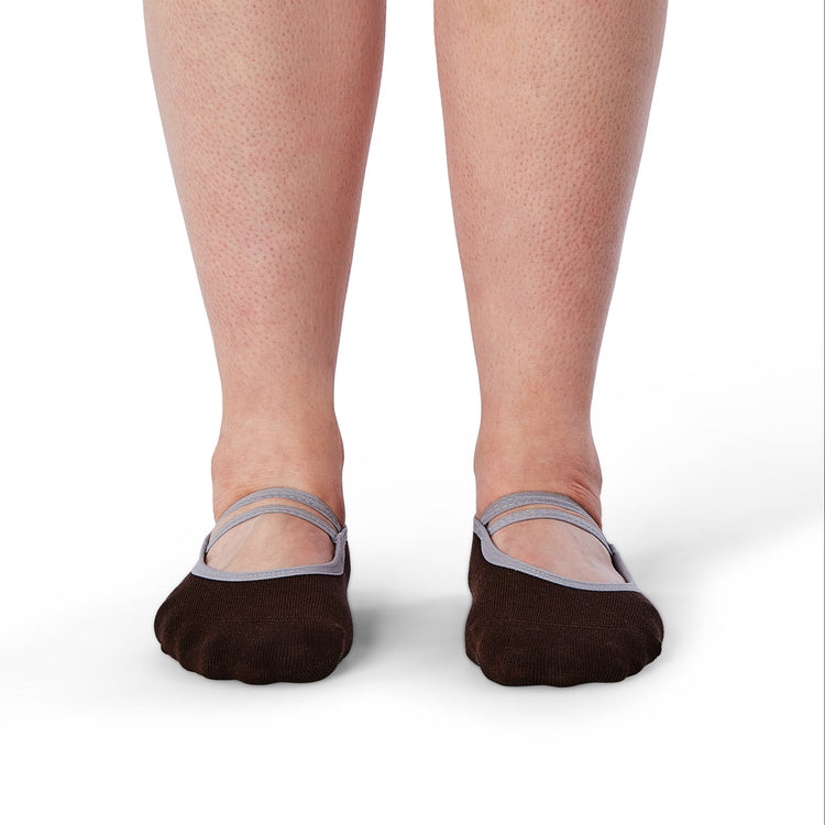 Brown socks with gray straps worn by a person on a white background
