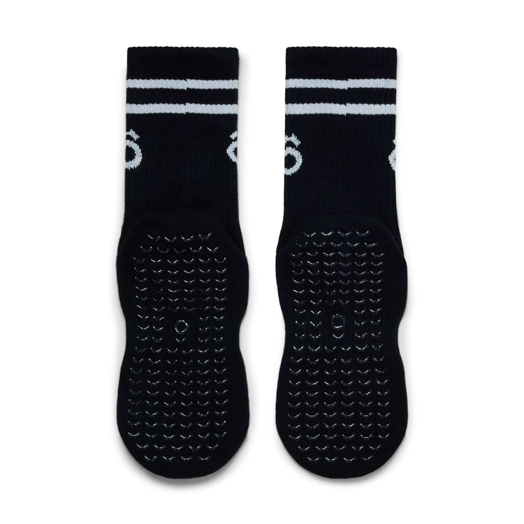 Black socks with white stripes and textured sole on a white background