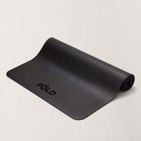 September Accessories Bundle - Black FOLD Yoga Mat with rolled edge on a light background.