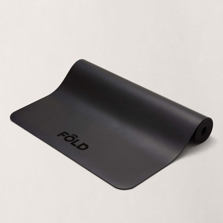 September Accessories Bundle - Black FOLD Yoga Mat with rolled edge on a light background.