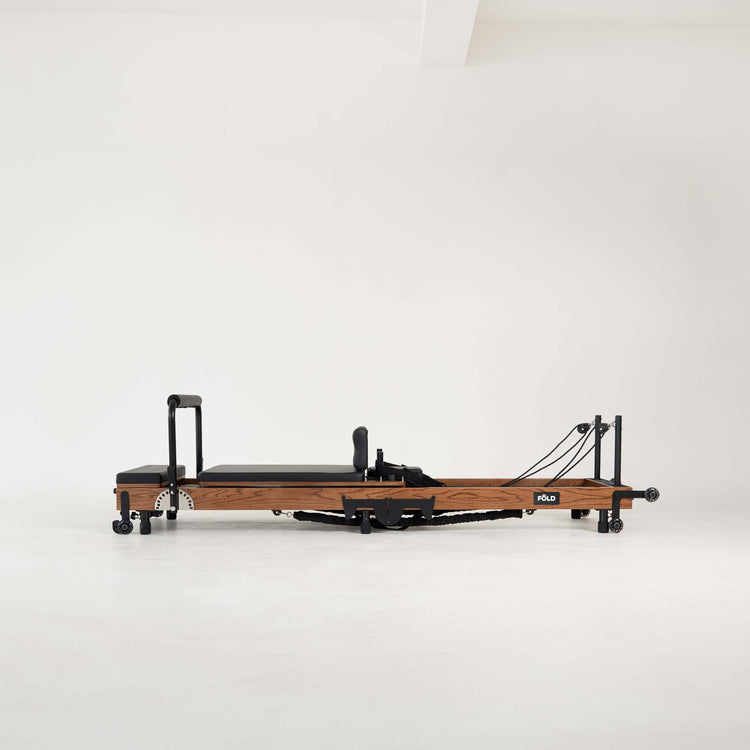 Wooden Pilates reformer on a white background