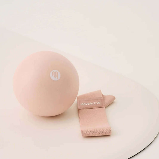 Soft pink Pilates Ball and Resistance band on a light coloured mat