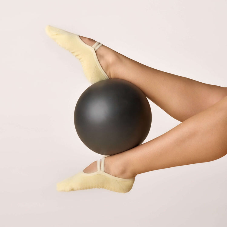 Ballet Grip Socks - Butter Yellow worn during workout with a black exercise ball.