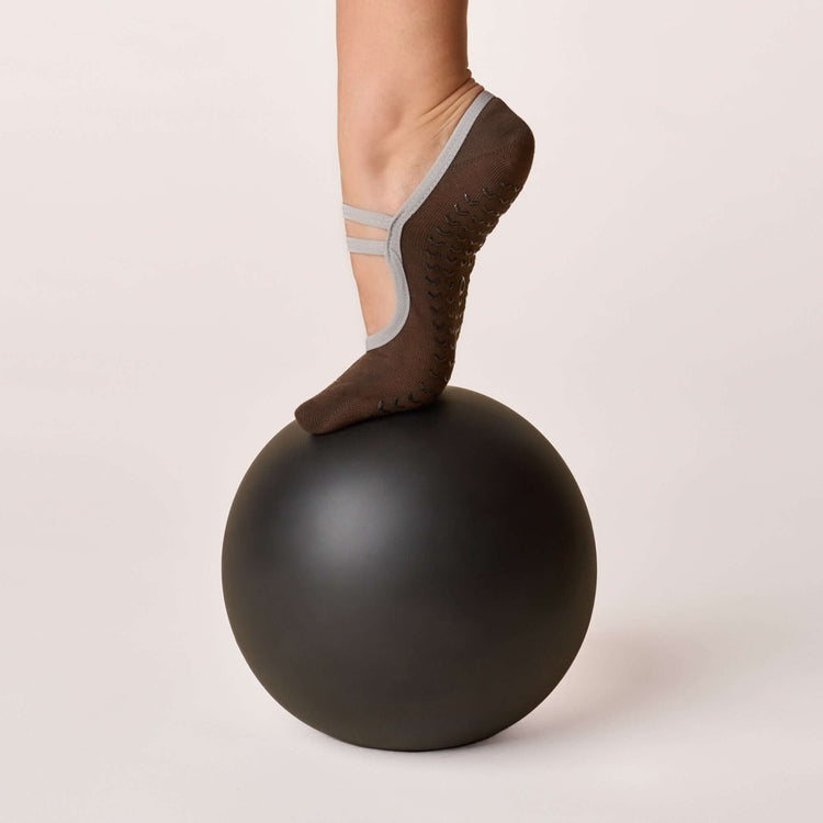 Ballet Grip Socks - Cocoa showcased on a foot balancing on a black exercise ball, highlighting non-slip design.