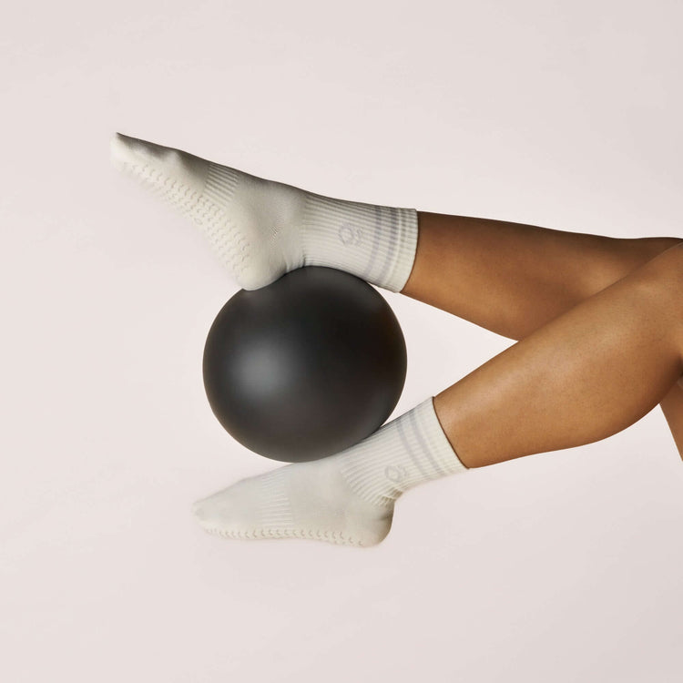Everyday Crew Grip Socks - Grey worn while balancing on a black exercise ball for fitness.