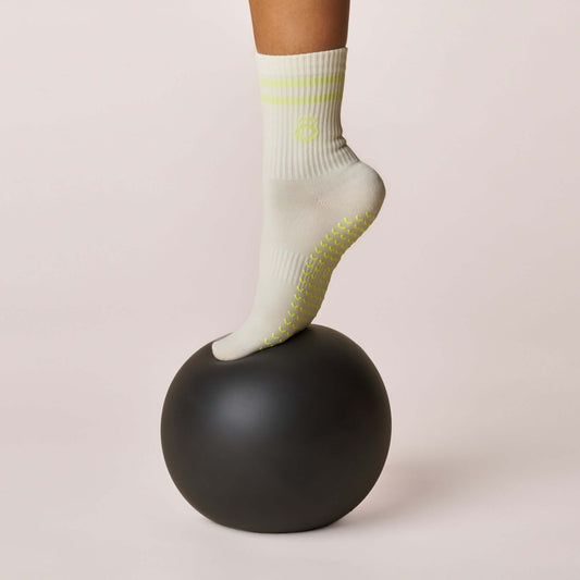 Everyday Crew Grip Socks - Lime worn on a black ball, showcasing its non-slip grip and soft cotton design.
