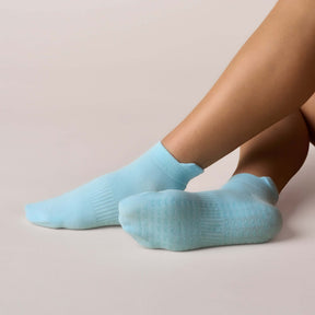 Pilates Low Rise Grip Socks - Baby Blue displayed on a foot, showcasing their low-rise design and grip sole.