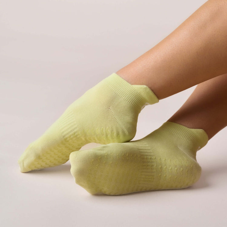 Pilates Low Rise Grip Socks - Lime displayed on feet showcasing comfort and grip for better movement.