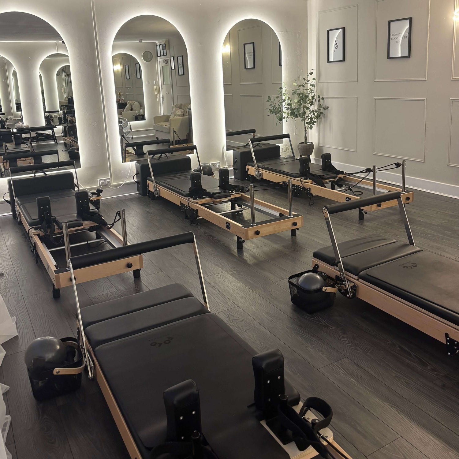 Pilates reformers in a studio with mirrors and decor