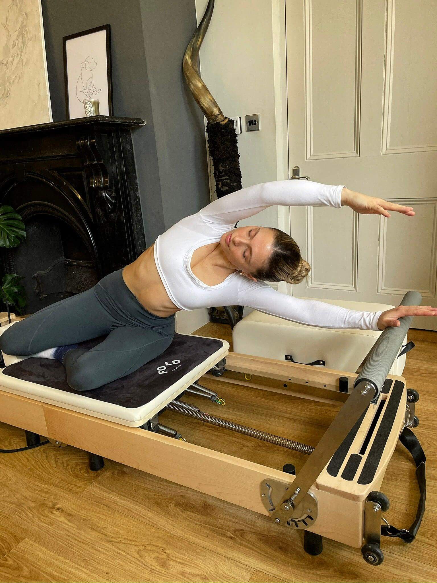 Pilates instructor stretching on a Foldable Pilates bed